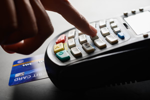 A person enters their pin number to complete a debit card purchase at a marijuana dispensary.